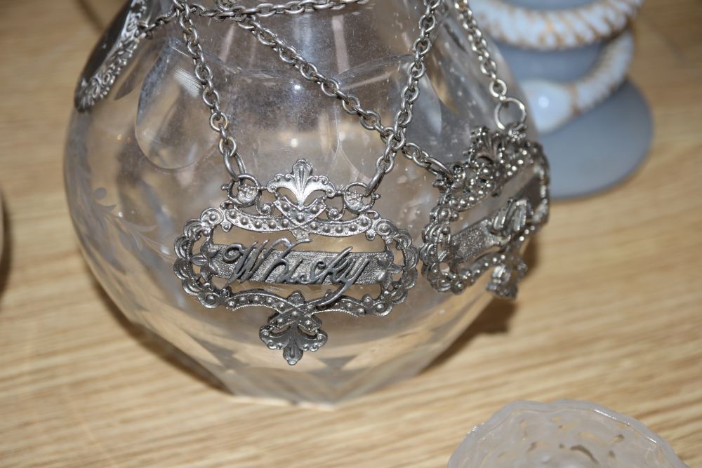 A pair of cut glass decanters, three other decanters, a claret jug and other glassware together with various labels, one silver whisky